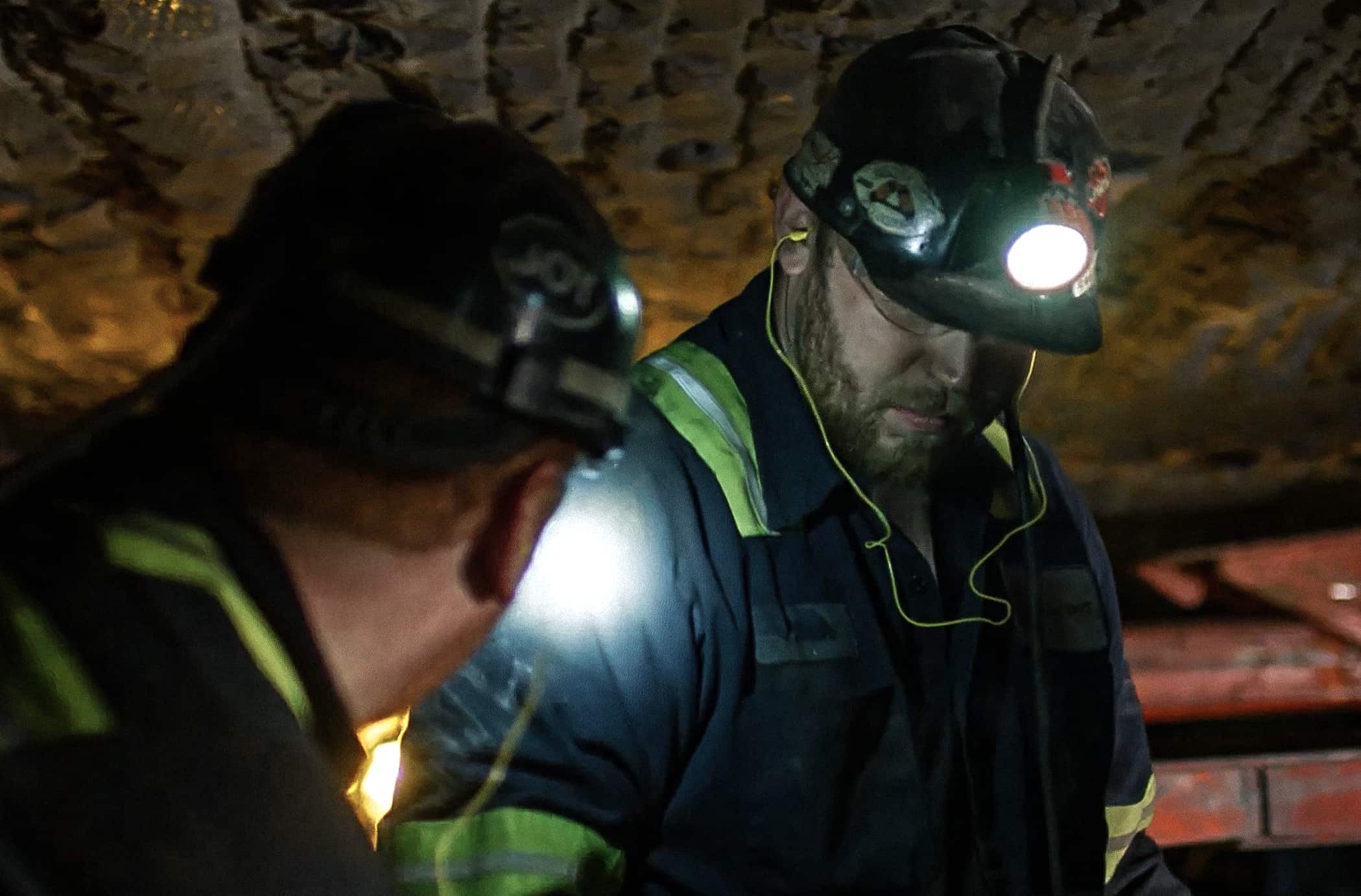 Mine workers examining something in the mine